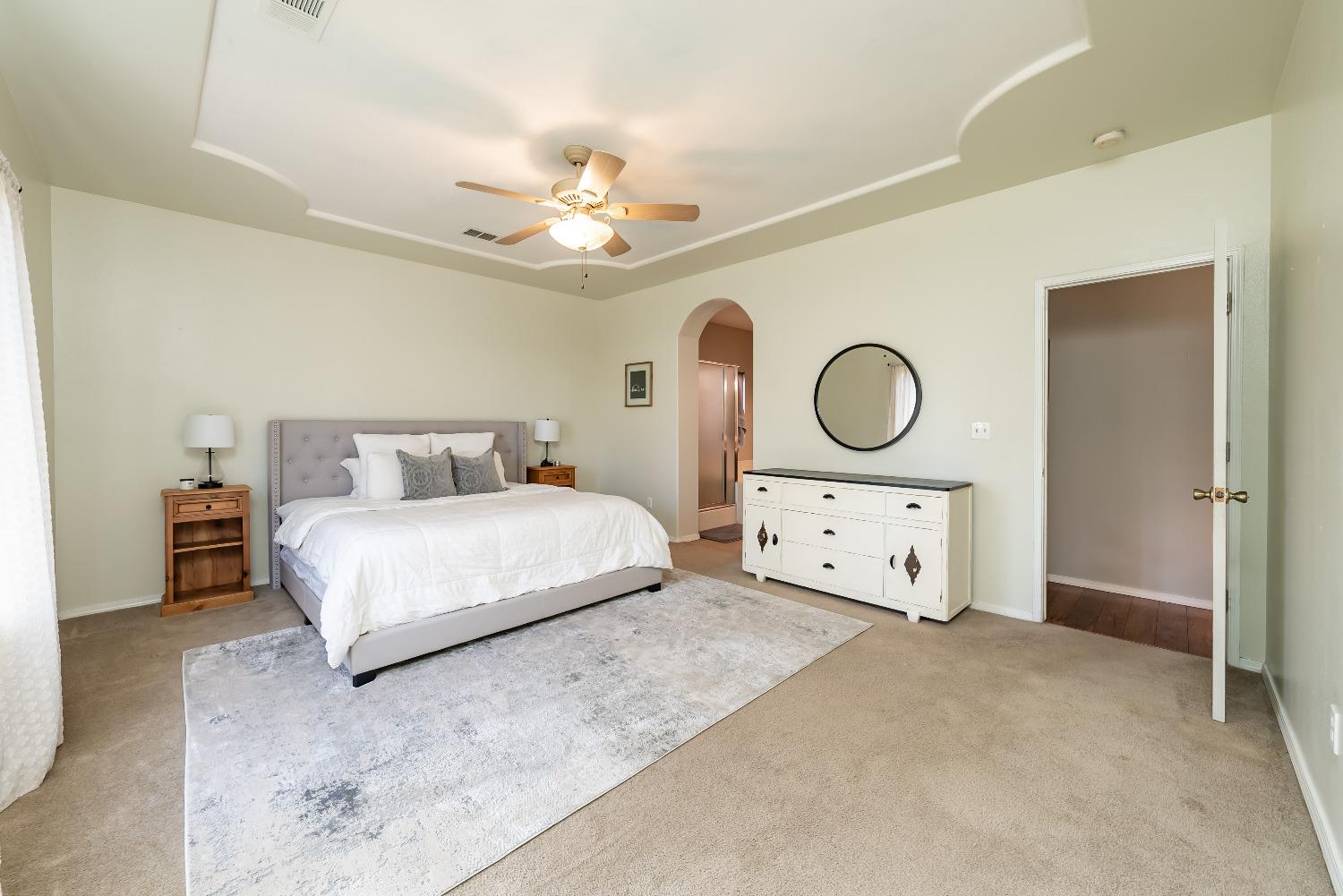 696 Crescent Lane Lemoore, CA 93245 - Photo 24 of 35 a bedroom with bed and a chandelier