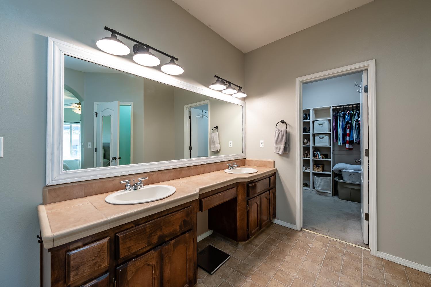 696 Crescent Lane Lemoore, CA 93245 - Photo 25 of 35 a spacious bathroom with a granite countertop sink and a mirror