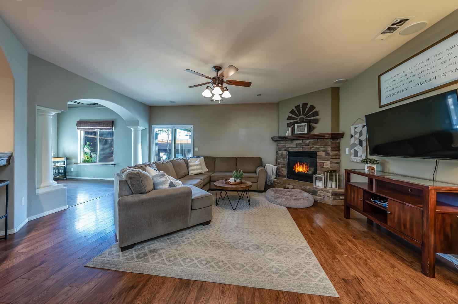 696 Crescent Lane Lemoore, CA 93245 - Photo 5 of 35 a living room with furniture a flat screen tv and a fireplace