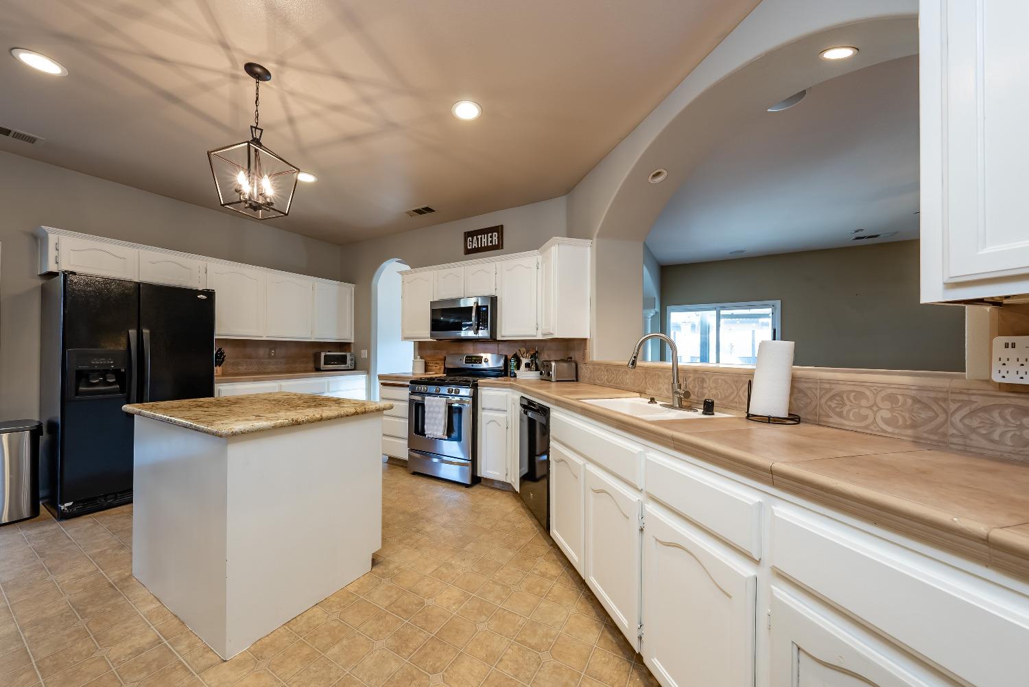 696 Crescent Lane Lemoore, CA 93245 - Photo 10 of 35 a kitchen with granite countertop kitchen island a sink stainless steel appliances and cabinets