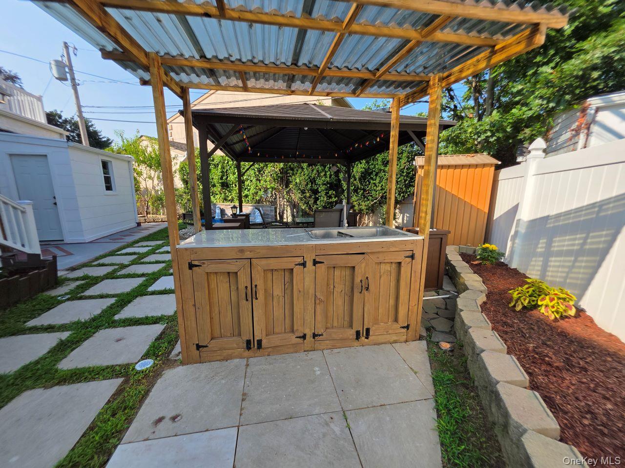30 Aberdeen Road New Hyde Park, NY 11040 - Photo 15 of 37 a view of a backyard with table and chairs with wooden fence