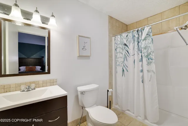 a view of swimming pool with lawn chairs and wooden fence