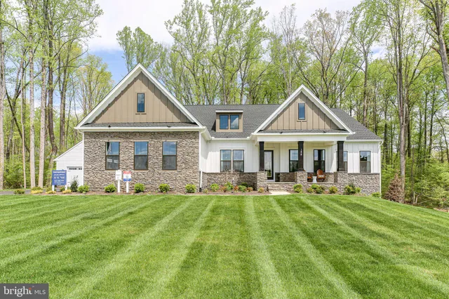 a front view of a house with a yard and trees