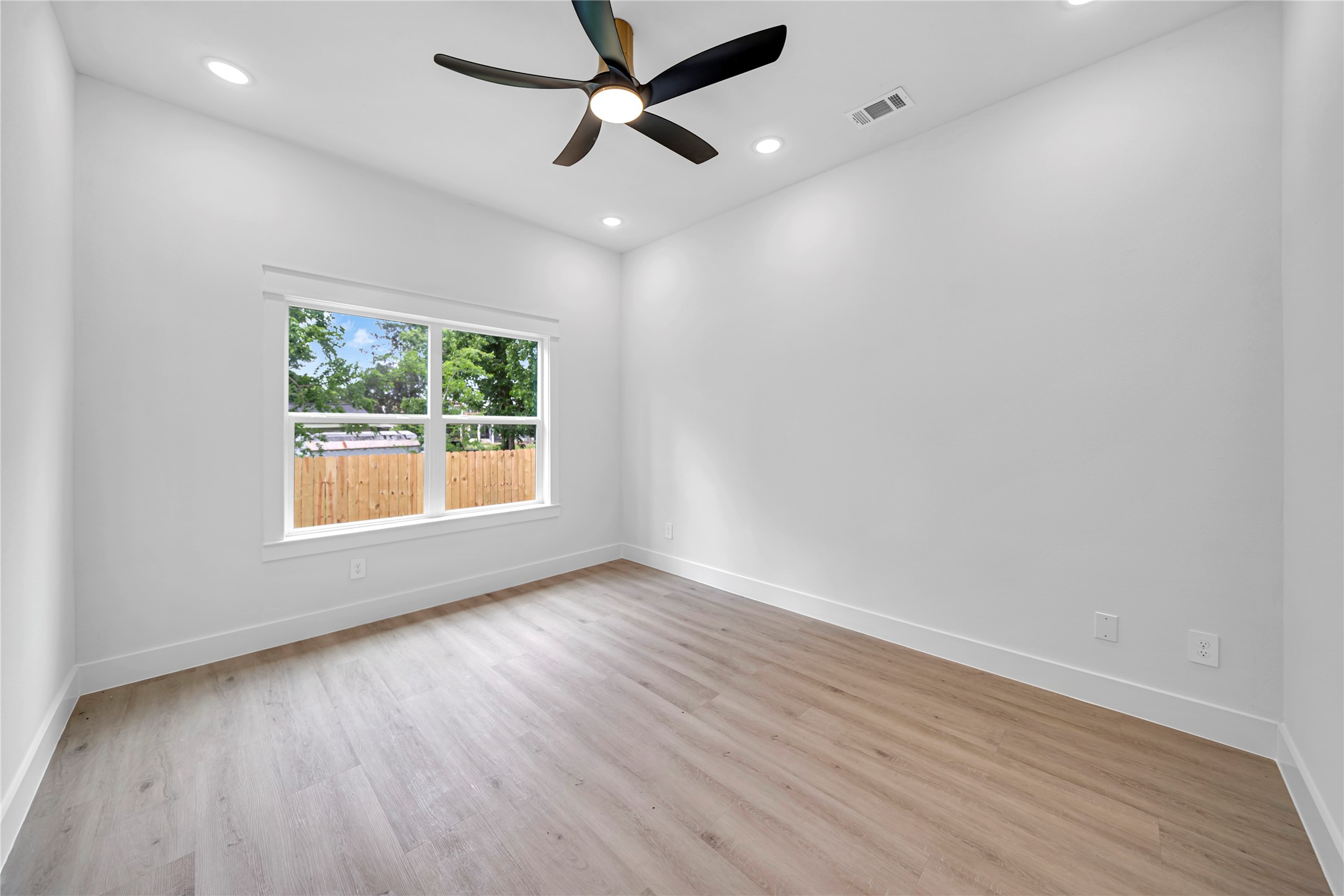 4902 Higgins Street, Unit B Houston, TX 77033 - Photo 22 of 24 an empty room with wooden floor chandelier fan and windows