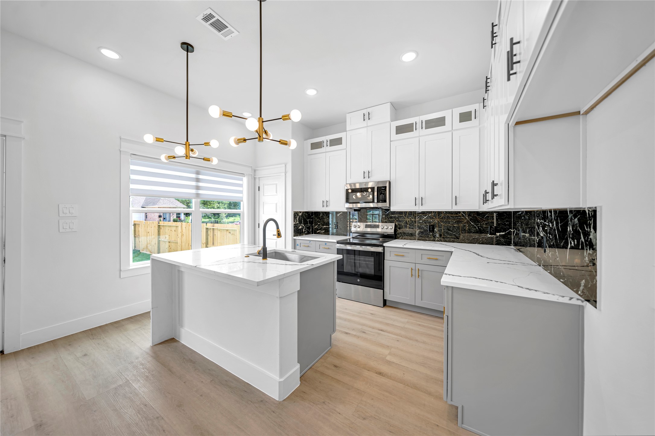 4902 Higgins Street, Unit B Houston, TX 77033 - Photo 5 of 24 a kitchen with stainless steel appliances kitchen island granite countertop a stove a sink and white cabinets