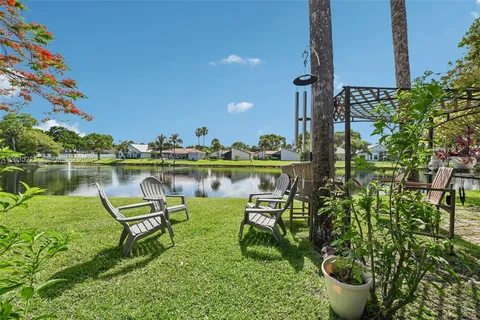 a swimming pool with barbeque oven table and chairs