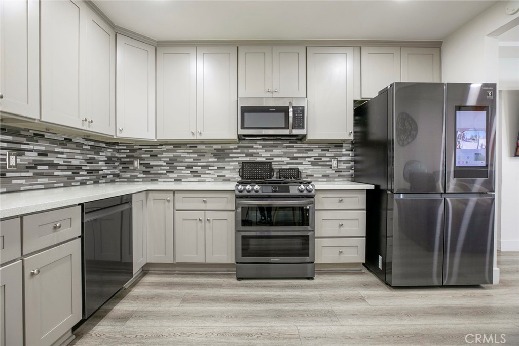 11836 Rialto Street Sun Valley, CA 91352 - Photo 9 of 23 a kitchen with white cabinets and stainless steel appliances