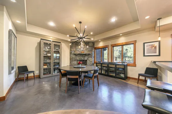 a dining room with wooden floor a chandelier a wooden table and chairs