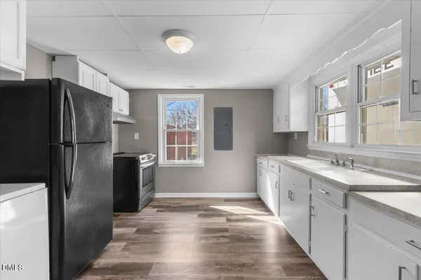 a kitchen with granite countertop a sink cabinets stainless steel appliances and a window