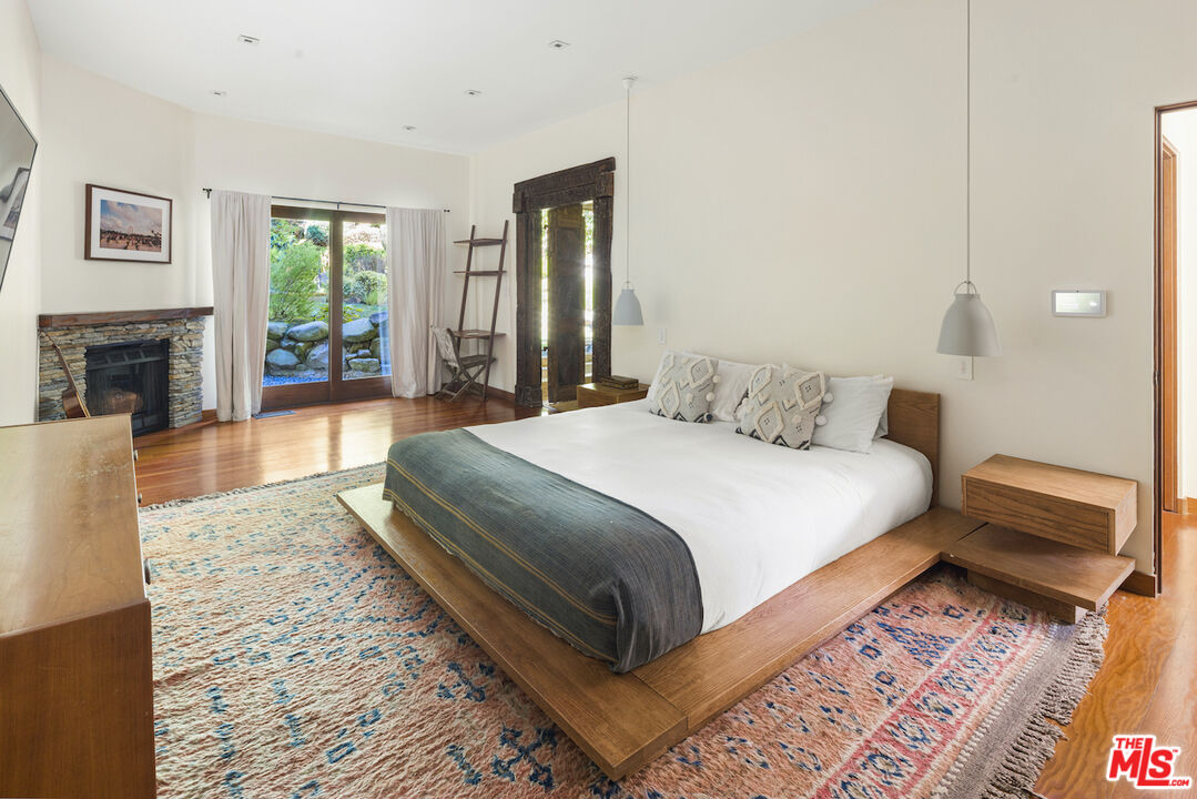 473 West Rustic Road Santa Monica, CA 90402 - Photo 21 of 34 a bedroom with a bed and a fireplace