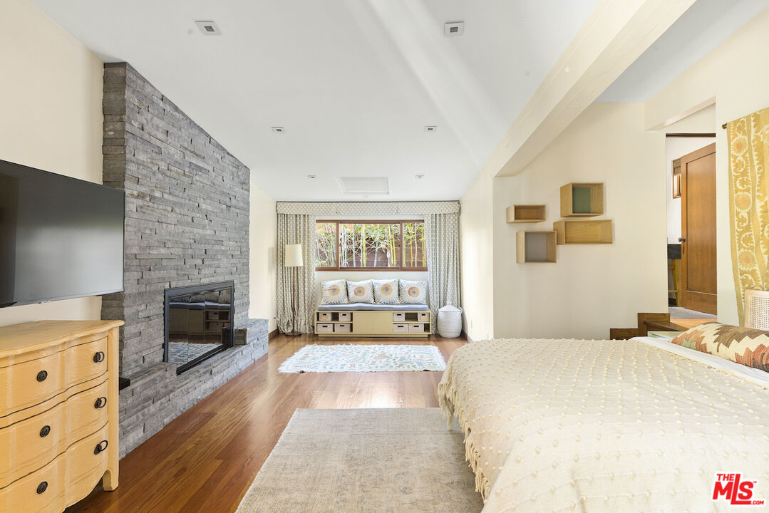 473 West Rustic Road Santa Monica, CA 90402 - Photo 23 of 34 a spacious bedroom with a bed and a fireplace