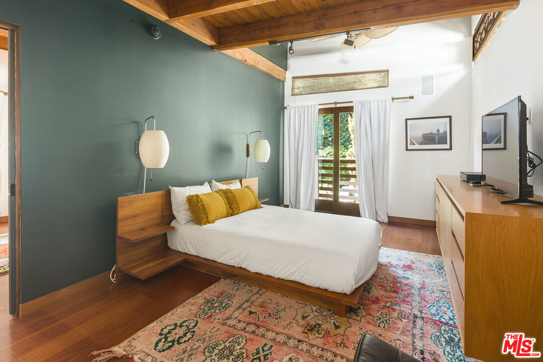 473 West Rustic Road Santa Monica, CA 90402 - Photo 27 of 34 a bedroom with a bed and wooden floor