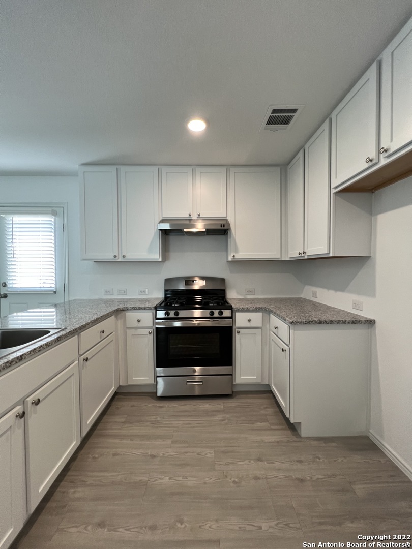 7314 Silos Ridge San Antonio, TX 78252 - Photo 11 of 45 a kitchen with granite countertop white cabinets and appliances