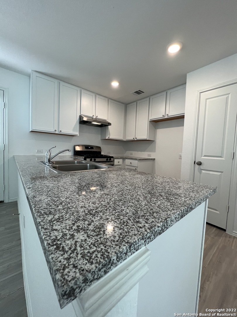 7314 Silos Ridge San Antonio, TX 78252 - Photo 16 of 45 a kitchen with stainless steel appliances granite countertop a sink stove and refrigerator