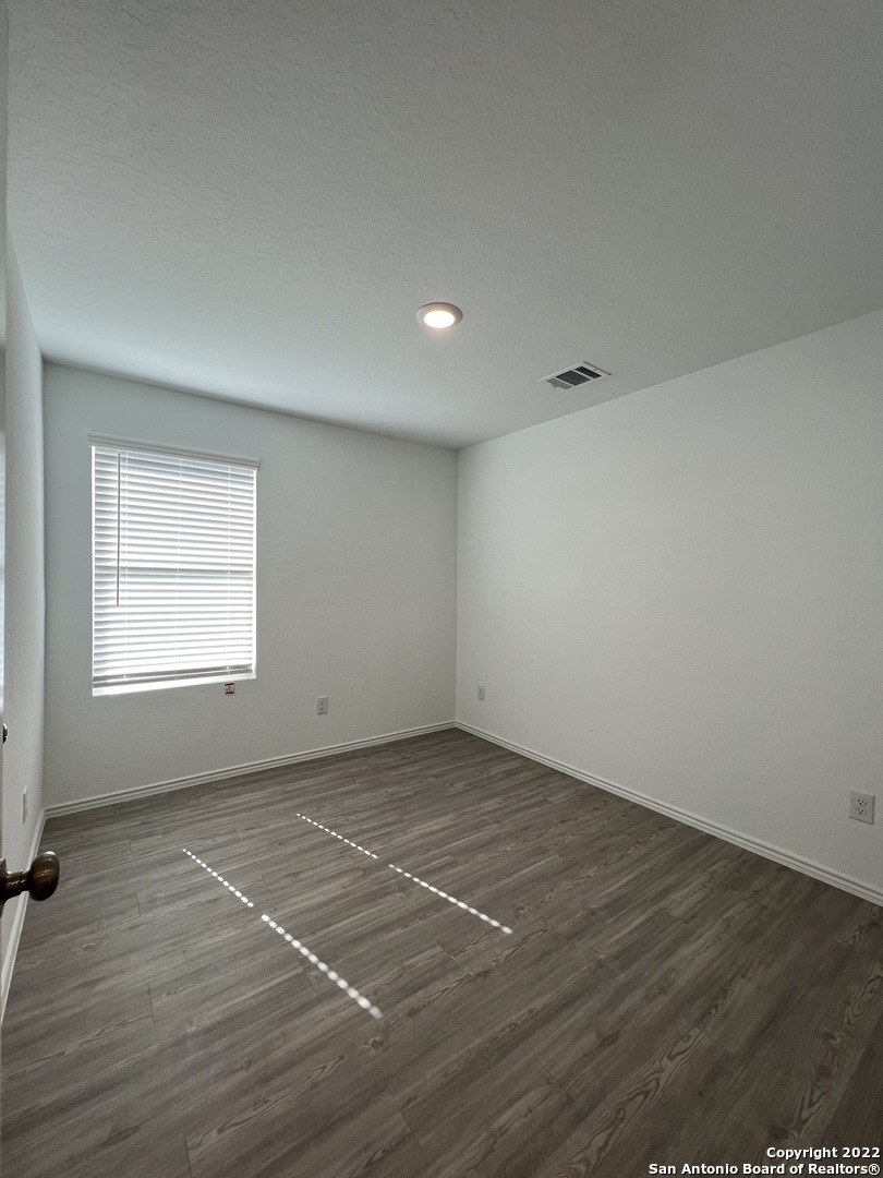 7314 Silos Ridge San Antonio, TX 78252 - Photo 18 of 45 an empty room with wooden floor and windows
