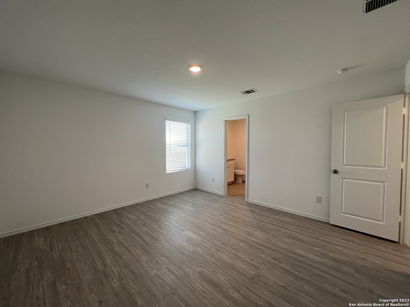 7314 Silos Ridge San Antonio, TX 78252 - Photo 28 of 45 an empty room with wooden floor and windows