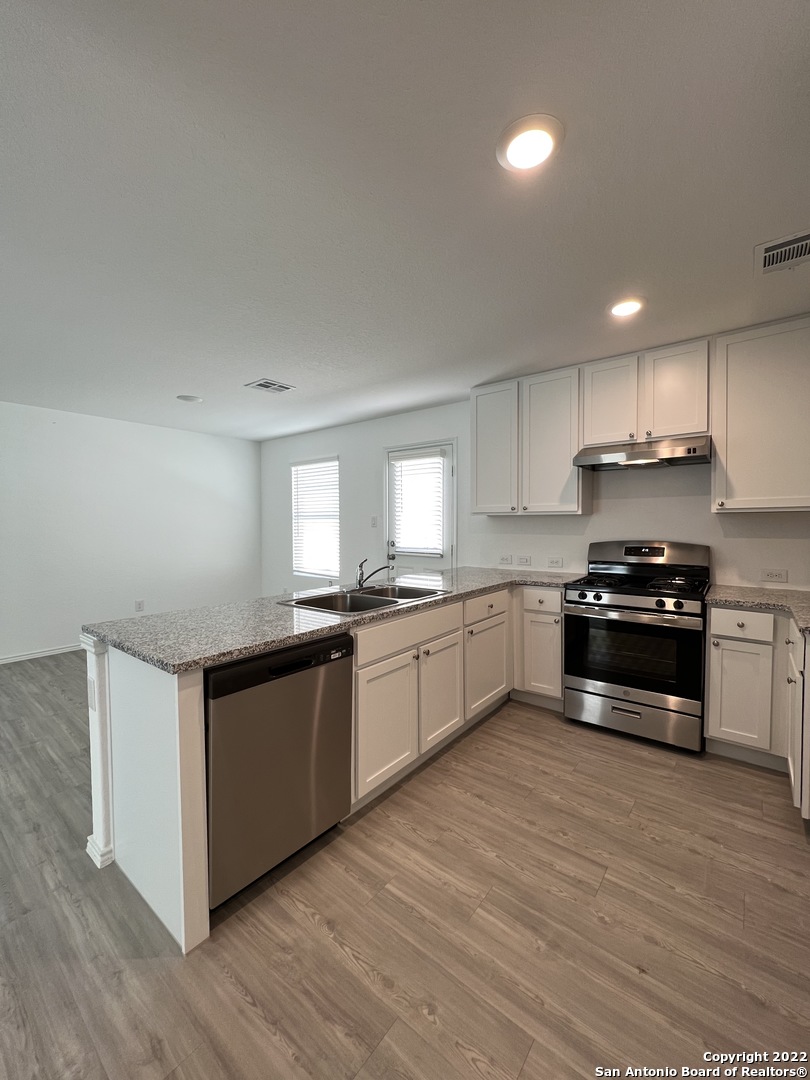 7314 Silos Ridge San Antonio, TX 78252 - Photo 10 of 45 a kitchen with granite countertop a stove top oven and cabinets