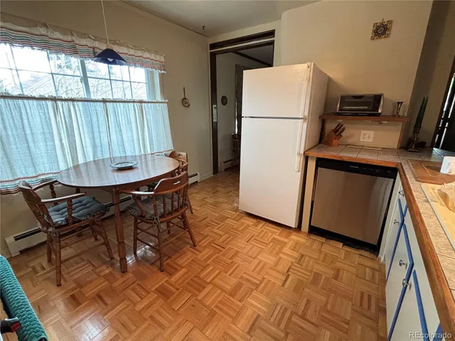 a view of a kitchen with furniture and a refrigerator