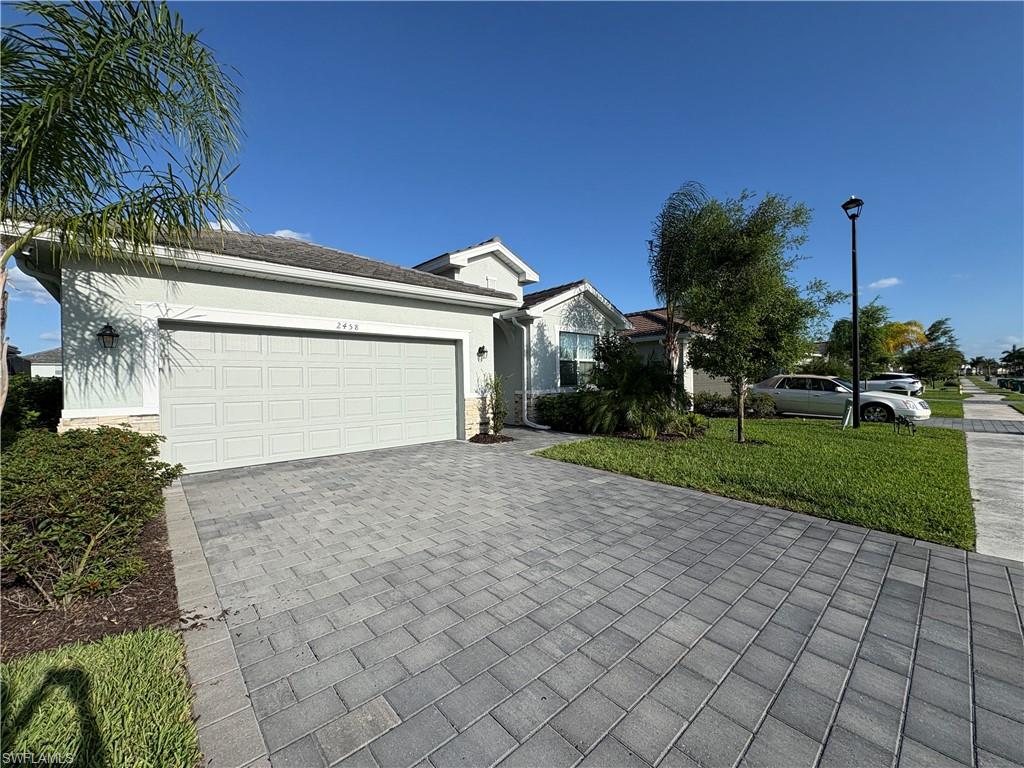 2458 Orchard Street Naples, FL 34120 - Photo 1 of 43 a front view of a house with a yard and a garage