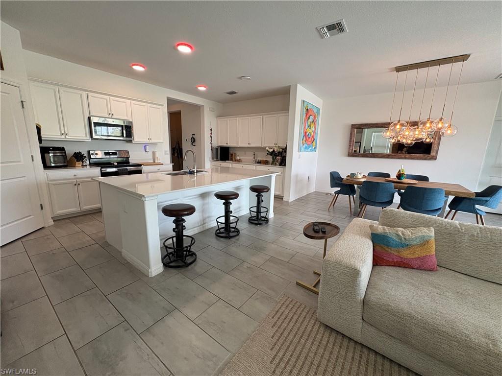 2458 Orchard Street Naples, FL 34120 - Photo 12 of 43 a kitchen with stainless steel appliances kitchen island granite countertop a sink and a refrigerator