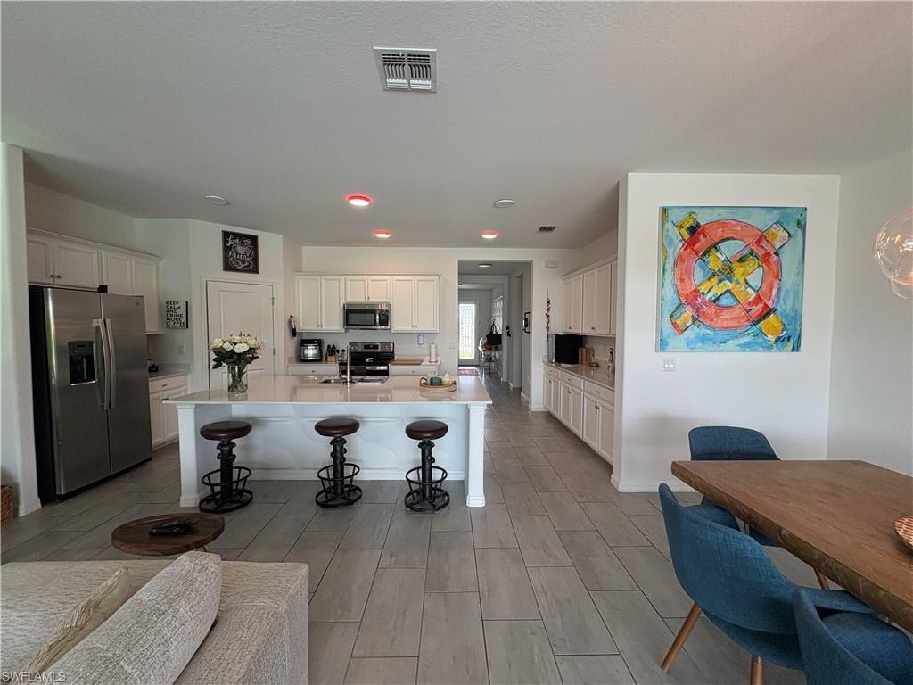 2458 Orchard Street Naples, FL 34120 - Photo 14 of 43 a living room with furniture a refrigerator and kitchen