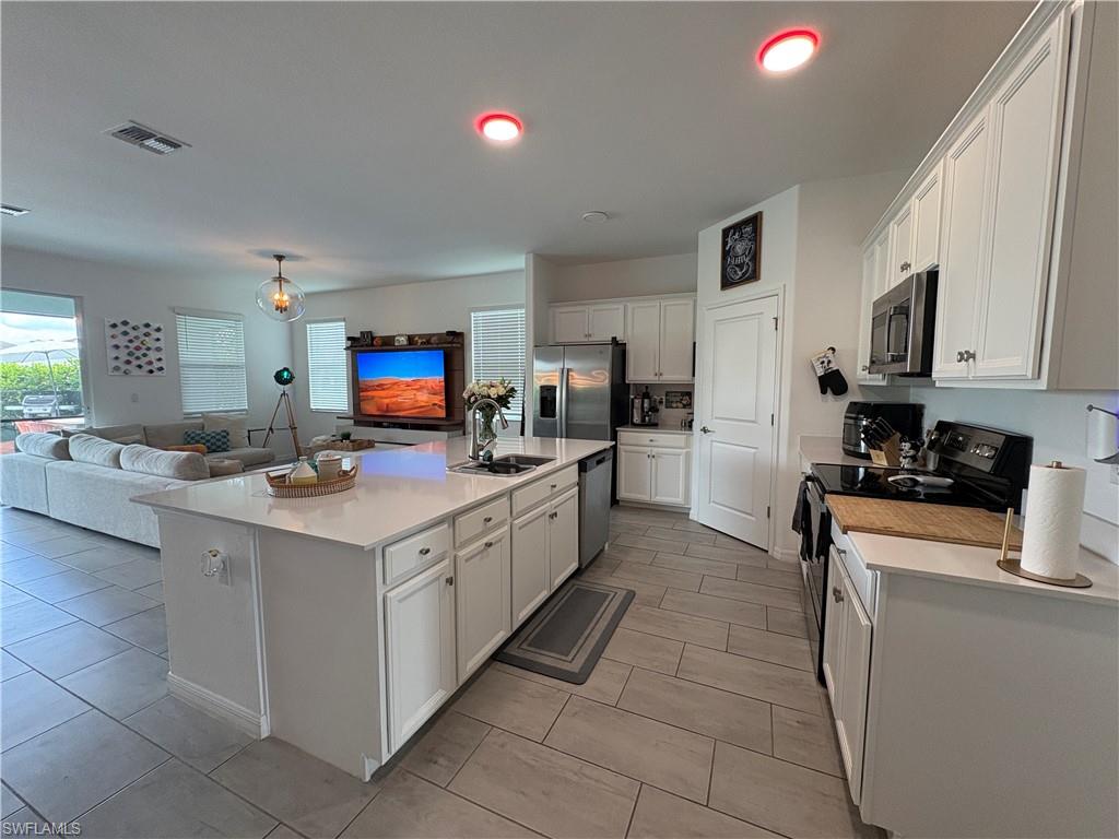 2458 Orchard Street Naples, FL 34120 - Photo 17 of 43 a kitchen with stainless steel appliances granite countertop a stove and a sink