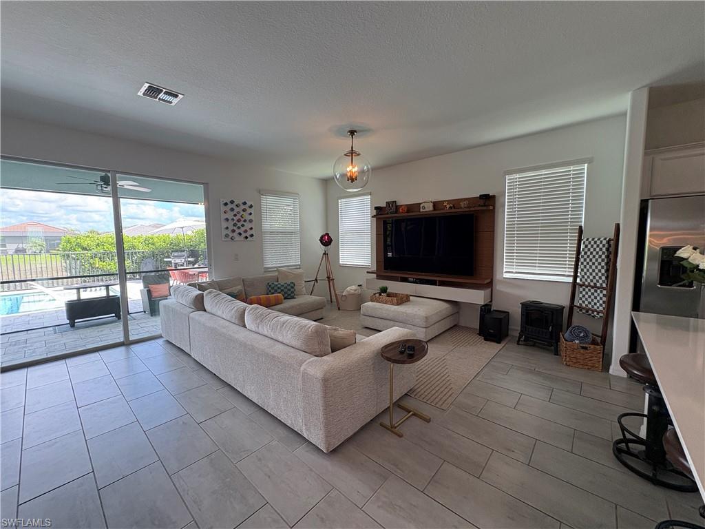 2458 Orchard Street Naples, FL 34120 - Photo 18 of 43 a living room with furniture and a flat screen tv