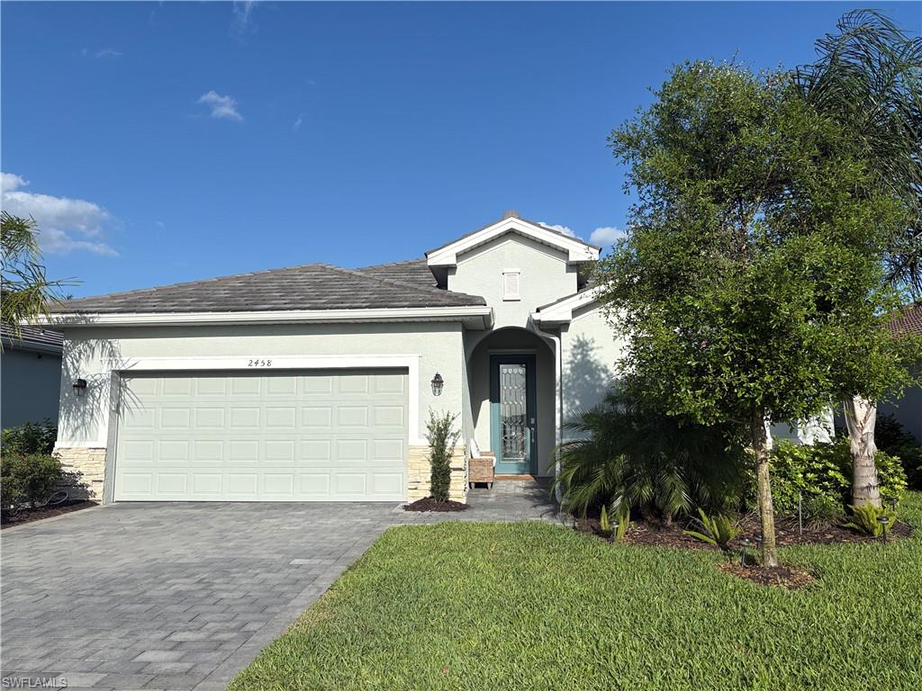 2458 Orchard Street Naples, FL 34120 - Photo 2 of 43 a front view of a house with a yard and garage