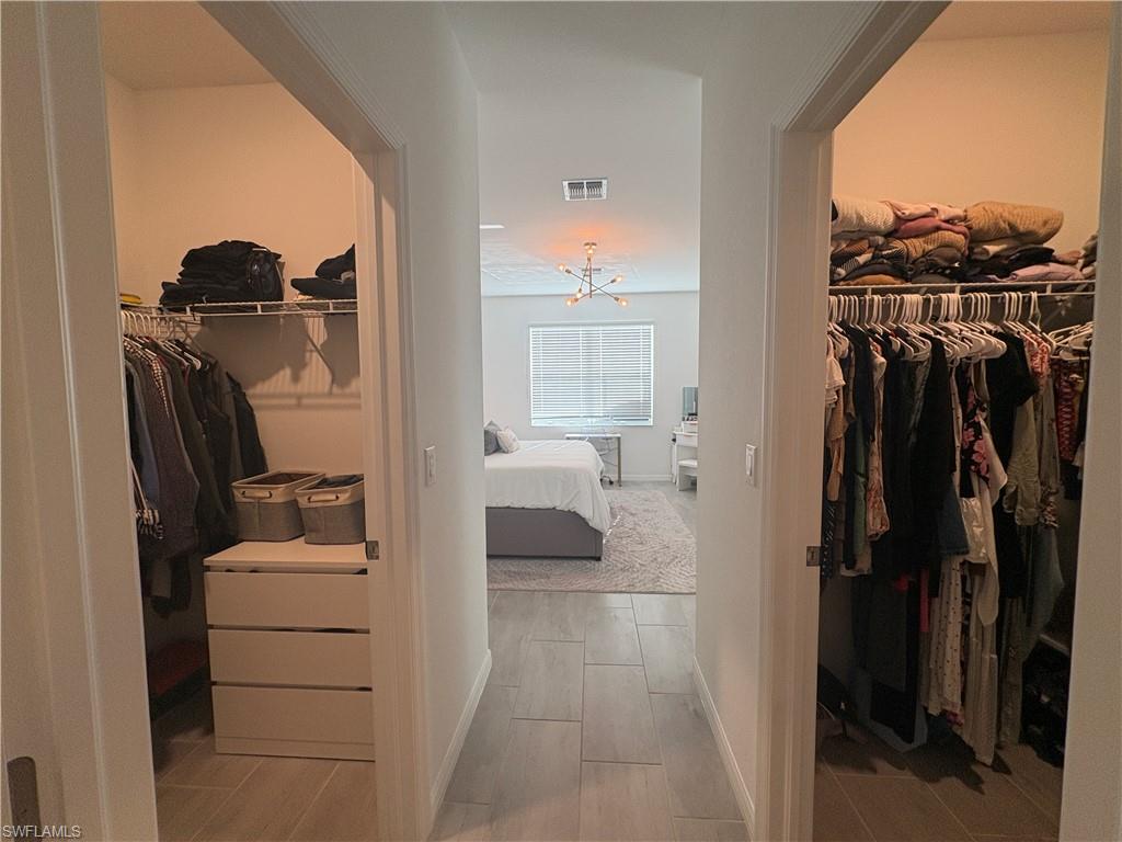 2458 Orchard Street Naples, FL 34120 - Photo 24 of 43 a view of walk in closet with clothes and shoes