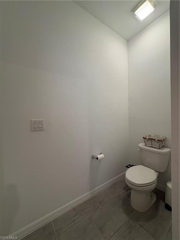 2458 Orchard Street Naples, FL 34120 - Photo 27 of 43 a white toilet sitting next to a white sink and vanity