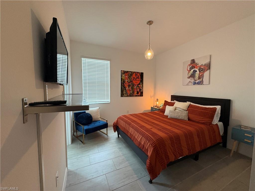2458 Orchard Street Naples, FL 34120 - Photo 28 of 43 a bedroom with a bed and a flat screen tv