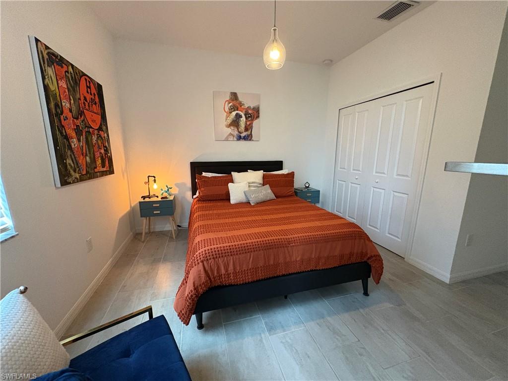 2458 Orchard Street Naples, FL 34120 - Photo 29 of 43 a bedroom with a bed and wooden floor