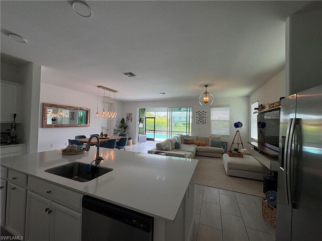2458 Orchard Street Naples, FL 34120 - Photo 36 of 43 a kitchen with sink refrigerator and stove top oven