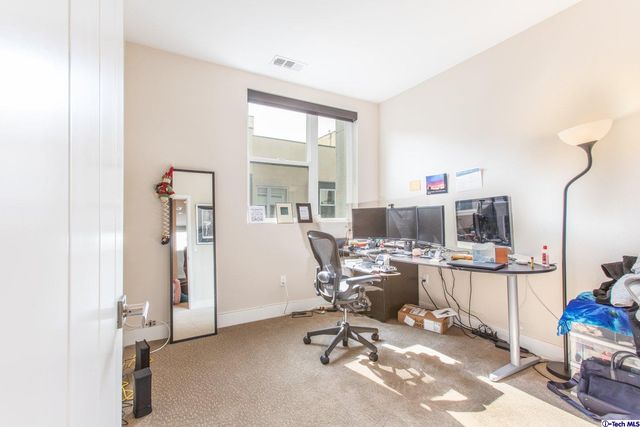 a bedroom with a bed and large windows