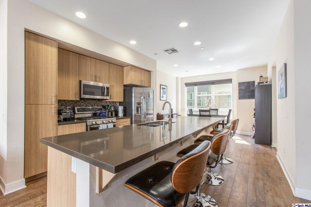 a kitchen with kitchen island granite countertop lots of counter top space and stainless steel appliances