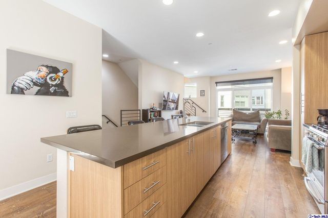 a kitchen with counter top space a sink cabinets and wooden floor