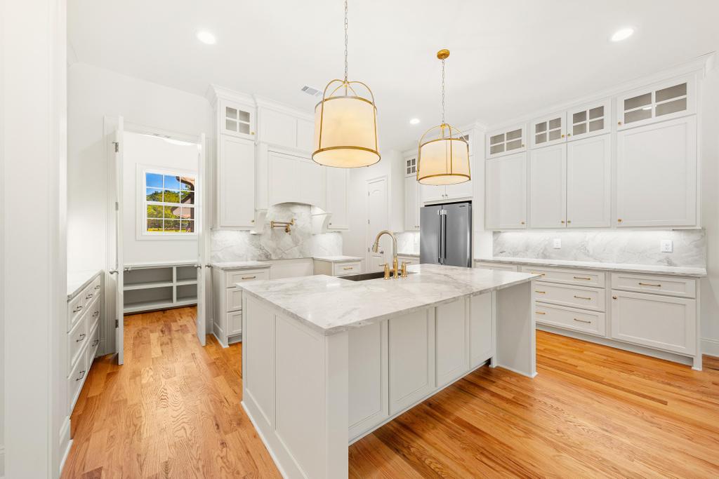 707 Vickery Street Extension Hartwell, GA 30643 - Photo 10 of 50 Culinary delights await in this bright kitchen with a spacious island, premium finishes, and rich hardwood floors.
