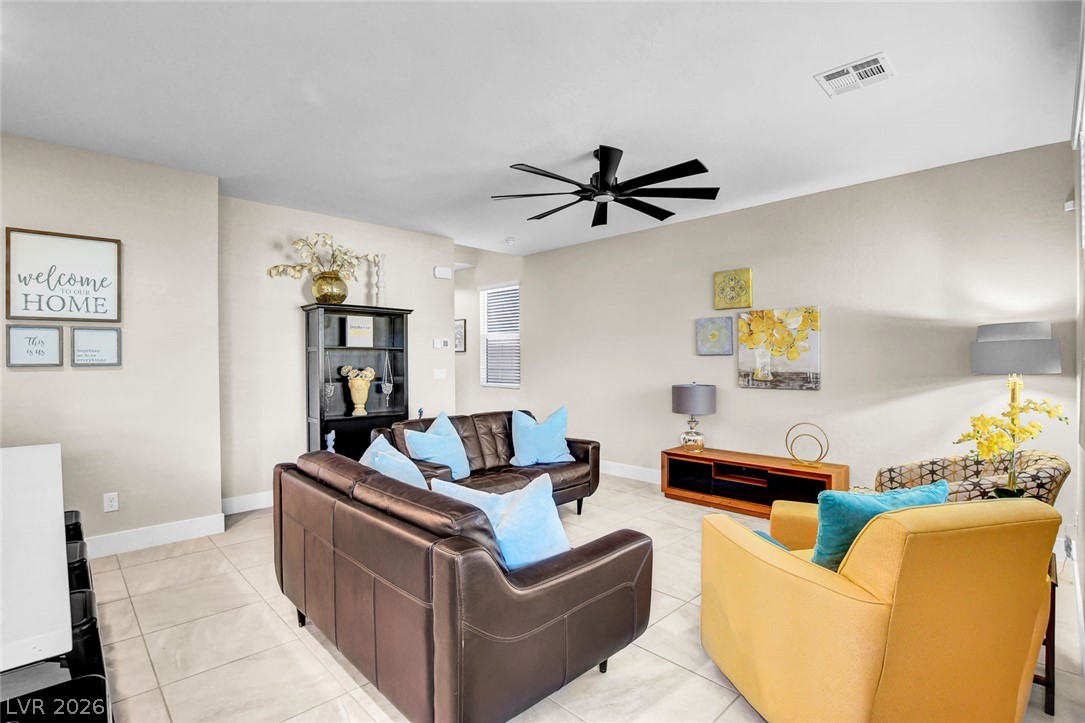 9688 Rankin Rdg Court Las Vegas, NV 89178 - Photo 8 of 53 A generously proportioned living room features durable tile flooring and a sleek ceiling fan.