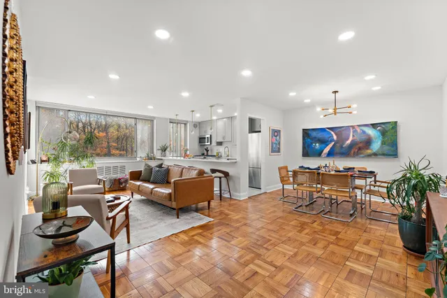 a living room with furniture a floor to ceiling window and a table