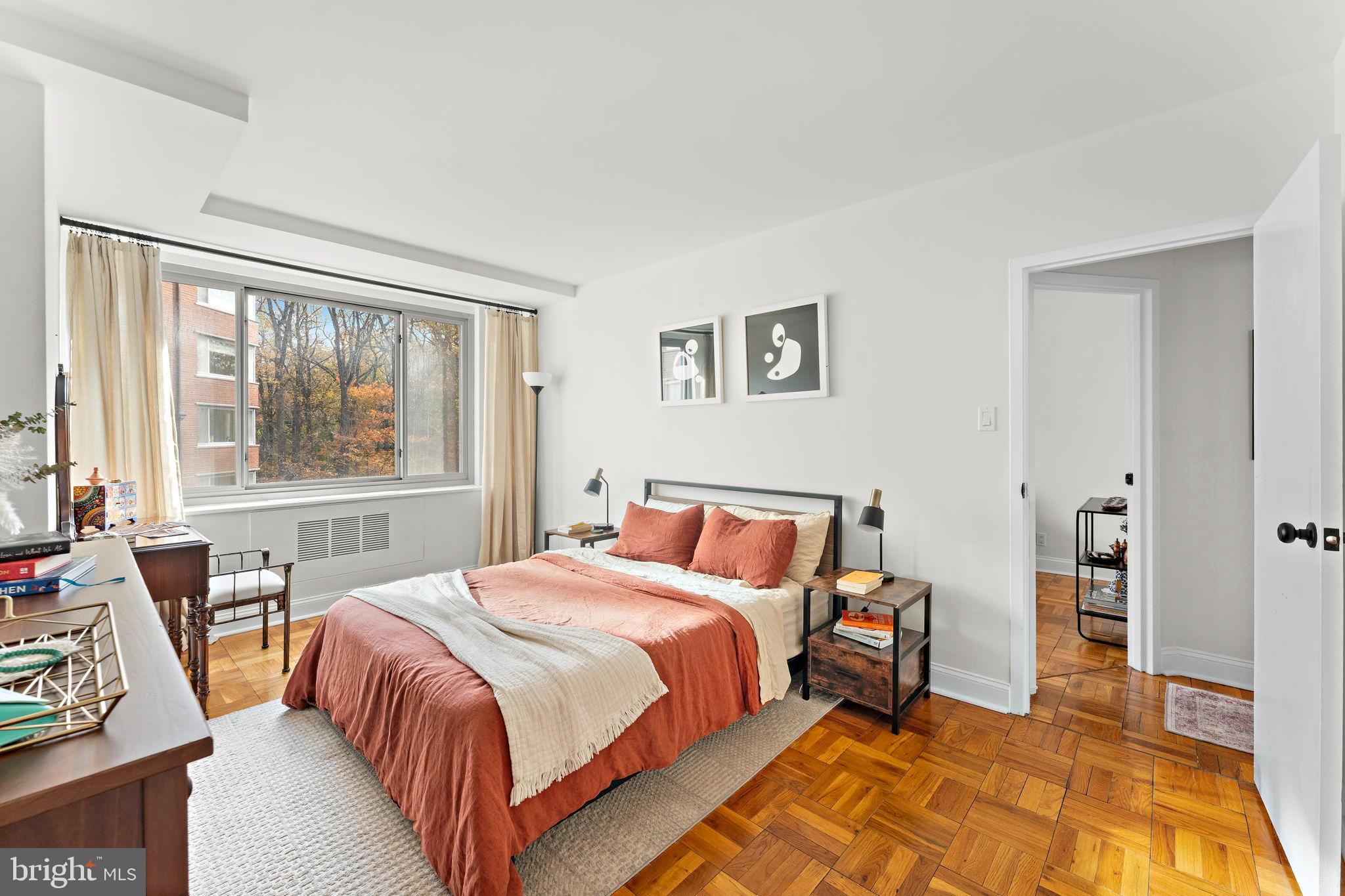 4200 Cathedral Avenue Northwest, Unit 610 Washington, DC 20016 - Photo 15 of 22 a bedroom with a bed and wooden floor