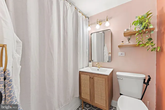 a bathroom with a toilet a sink and a mirror