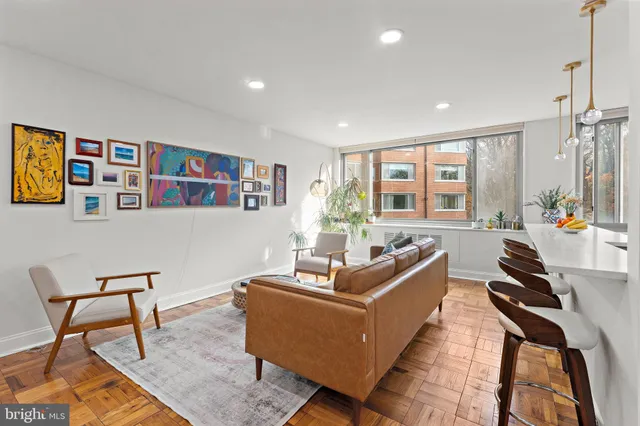 a living room with furniture a flat screen tv and a floor to ceiling window