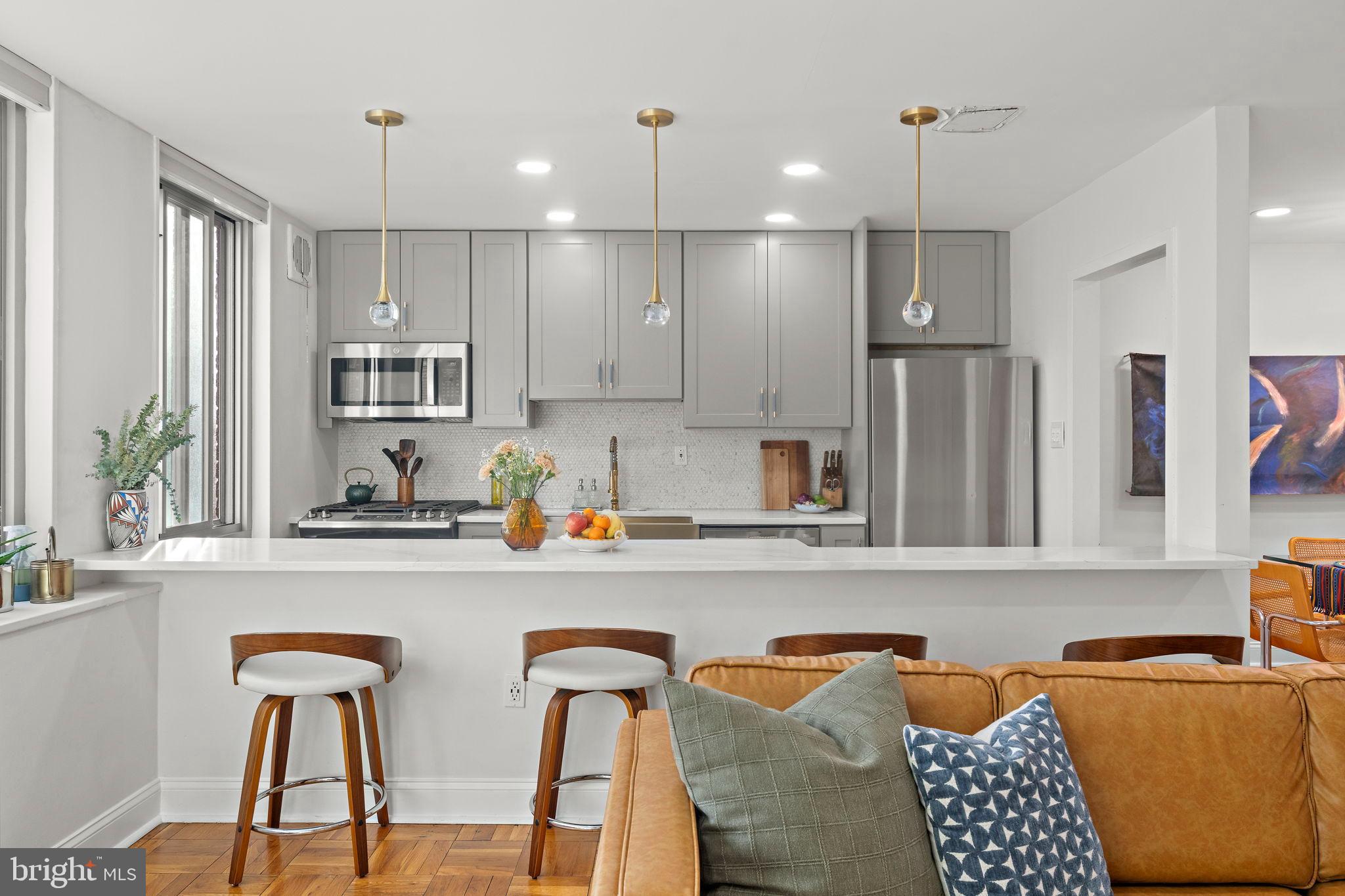4200 Cathedral Avenue Northwest, Unit 610 Washington, DC 20016 - Photo 7 of 22 a kitchen with stainless steel appliances granite countertop a refrigerator a sink dishwasher a dining table and chairs with wooden floor