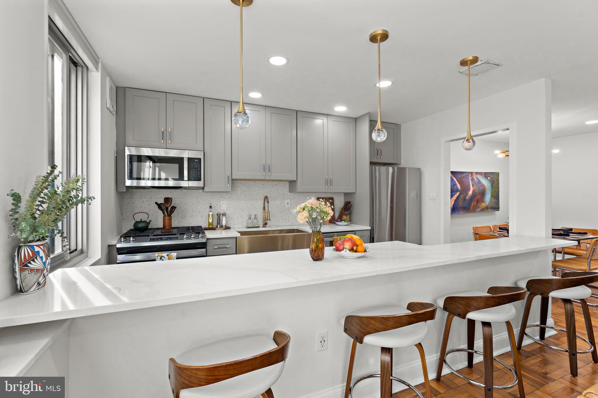 4200 Cathedral Avenue Northwest, Unit 610 Washington, DC 20016 - Photo 8 of 22 a kitchen with a sink a stove a refrigerator and chairs