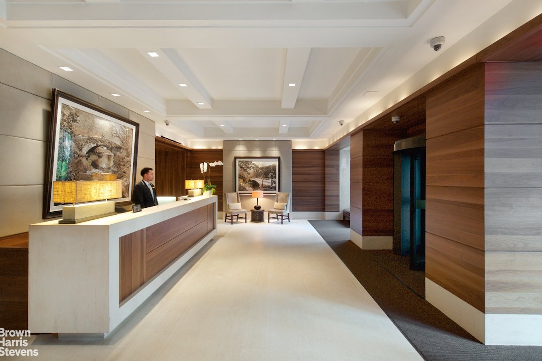 155 West 68th Street, Unit 28E Manhattan, NY 10023 - Photo 11 of 19 a large living room with stainless steel appliances kitchen island granite countertop a large window and a couch