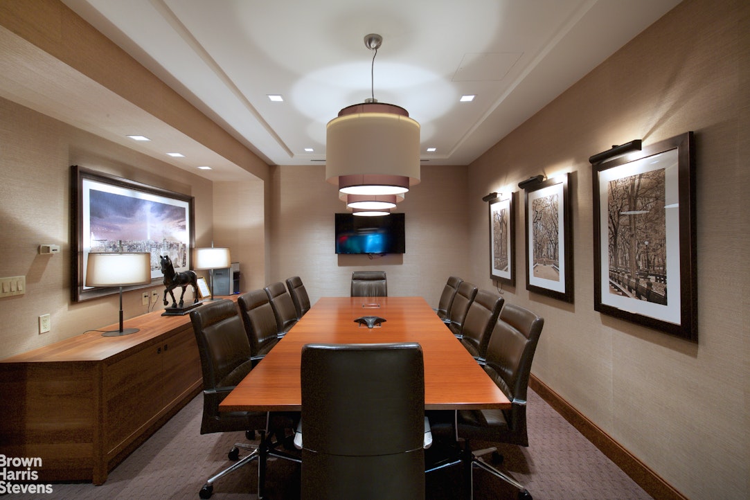 155 West 68th Street, Unit 28E Manhattan, NY 10023 - Photo 14 of 19 a living room with furniture a chandelier and a flat screen tv