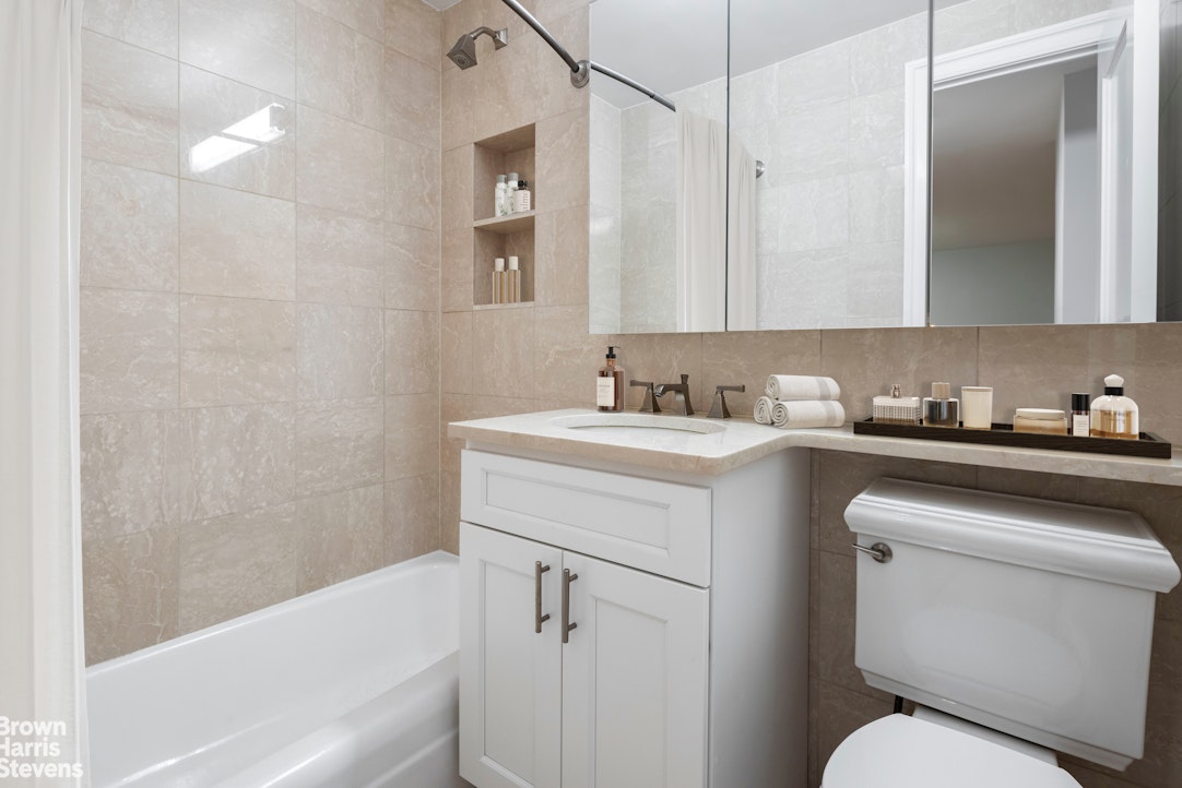 155 West 68th Street, Unit 28E Manhattan, NY 10023 - Photo 8 of 19 a bathroom with a sink toilet and vanity