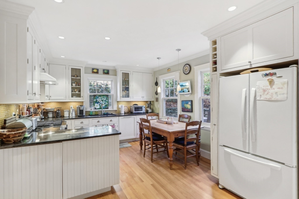 308 Prince Street Newton, MA 02465 - Photo 13 of 40 a kitchen with stainless steel appliances granite countertop a refrigerator a sink a stove and white cabinets with wooden floor