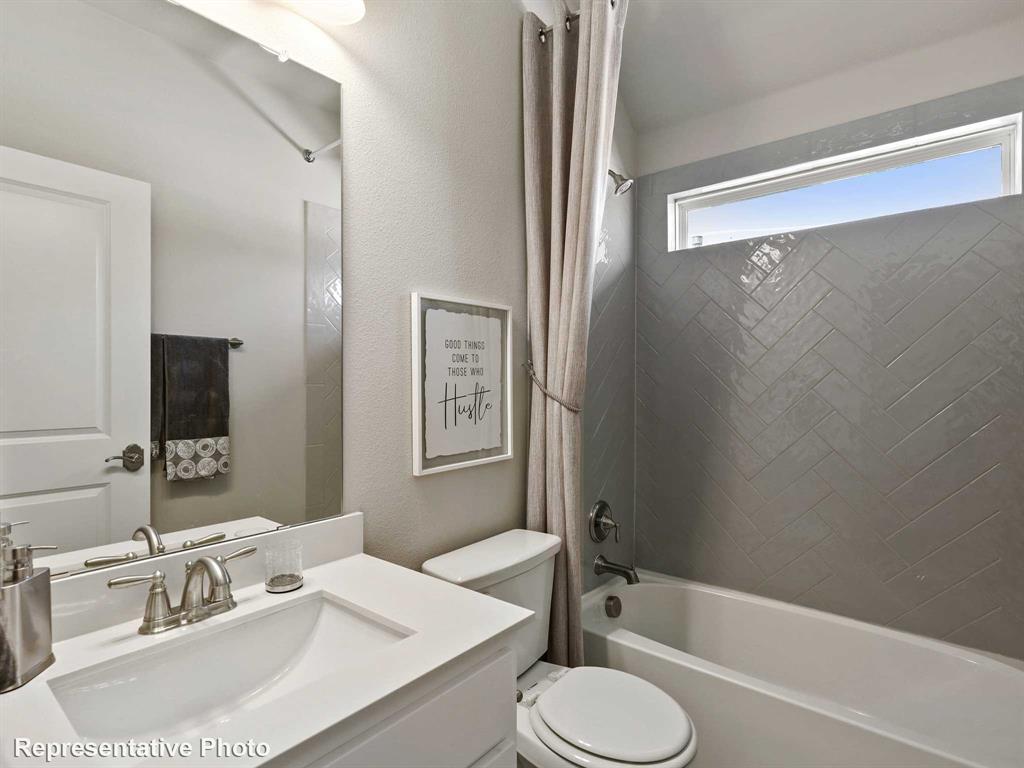 1143 Rothland Lane Red Oak, TX 75154 - Photo 17 of 18 Bathroom featuring a vanity with an integrated sink, a large mirror, and a bathtub with a tiled surround
