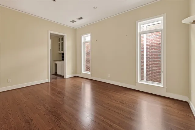 a view of a big room with wooden floor and windows